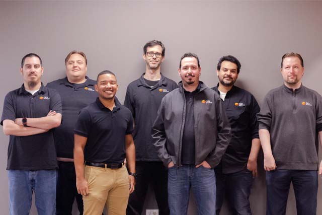 Group photo of CIO Solutions Fresno technical team standing in front of a gray wall