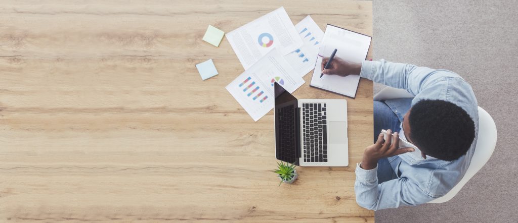 Top view of businessman working at wooden desk in office